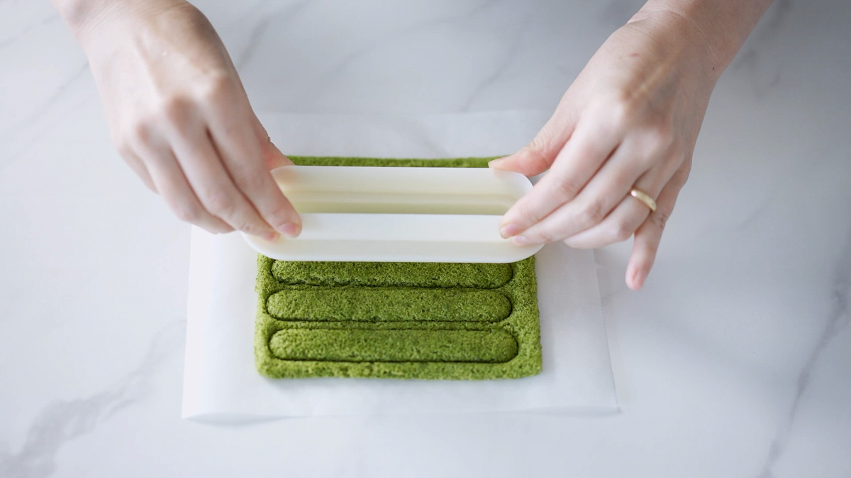 抹茶スポンジを小さい楕円型抜きでくり抜きます。スポンジはシリコン型の内側にぴったり収まるよう、タルト生地に使った大きい楕円型抜きより一回り小さい型で抜きます。